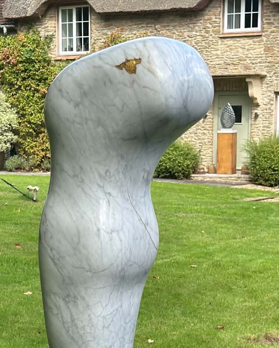 The crown of the finished sculpture in the garden, with gold filling an opening in the white marble